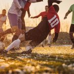 Group of people, male soccer players playing a match on a soccer field on winter day outdoors. Player performing a tackle – © South_agency - istockphoto.com - 1360149924