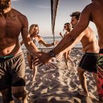 Junge Freunde begrüßen nach dem Beachvolleyball am Sommertag. – © skynesher - istockphoto.com - 1048059306